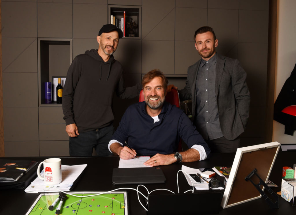 Jürgen Klopp underskriver en ny kontrakt omgivet af Mike Gordon og Julian Ward